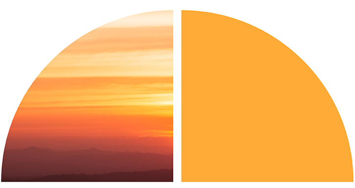 A warm sunset over layered mountains.